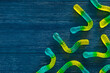 Blue and Yellow Gummy Worms on Blue Wood Background