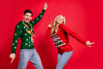 Sticker - Photo portrait laughing couple wearing sweaters dancing at xmas party celebrating holidays isolated vivid red color background