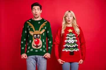 Sticker - Photo portrait amazed surprised couple wearing ugly sweaters celebrating xmas isolated bright red color background