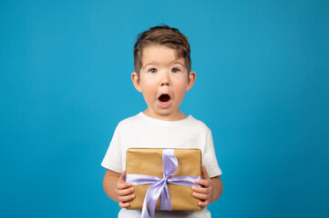 Wall Mural - Happy surpeised and cute child with his gift. Birthday boy concept