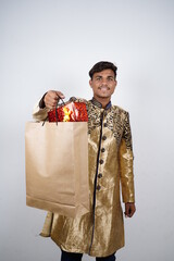 Wall Mural - Indian man in ethnic wear with shopping bags, isolated over yellow background