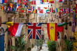 Flags of various countries hanging over one of the streets in Valletta, Malta.