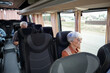 © pressmaster - Aged Caucasian woman with grey hair sitting by window inside bus and looking at road and country houses