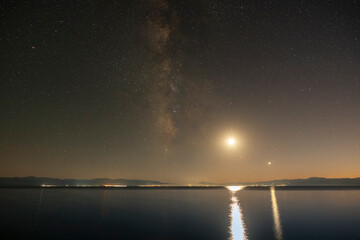 Wall Mural - night landscape, milky way galaxy and moon above the lake.