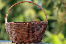 Vintage Wicker Basket On A Background Of Green Leaves