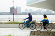 © Martin Barraud/Caia Image - Father and son riding bicycles along urban waterfront, London, UK