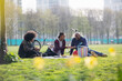 © Martin Barraud/Caia Image - Father and kids enjoying picnic in sunny urban park grass