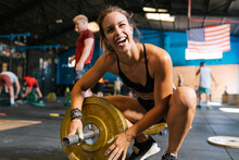 Cheerful Sportswoman Preparing Barbell For Workout