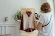 © Sergey Narevskih/Stocksy - Woman taking picture of wardrobe for ad on internet