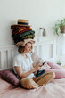 © Sergey Narevskih/Stocksy - Woman with stack of clothes using smartphone