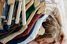 Stack Of Clothes With Hangers On Lying Woman