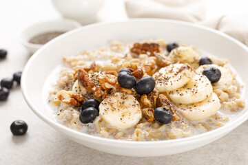 Poster - Oatmeal bowl. Oat porridge with banana, blueberry, walnut, chia seeds and almond milk for healthy breakfast or lunch. Healthy food, diet.