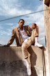 © Alba Vitta/Stocksy - Stylish man posing sitting on the rooftop wall