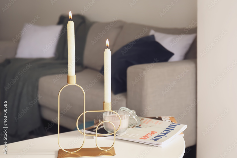 Aroma candles with magazines on table in room