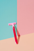 Pink Razor Leaning On A Blue And Pink Background