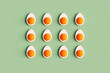 © Giada Canu/Stocksy - 3D render of boiled eggs cut in half organized on green