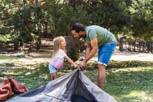 Man And Girl Pitching Tent Together