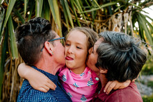 Happy Girl Hugging With Lesbian Parents