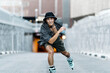 © Santi Nuñez/Stocksy - Young man roller skating forward looking at camera in the city