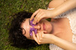 © Alba Vitta/Stocksy - Portrait of cute  woman laying on grass with flowers