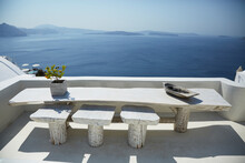 An Imperfect Wood Table And Stools With An Ocean View In Oia Greece
