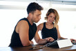 © Guille Faingold/Stocksy - Colleagues working with tablet at reception in gym
