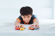 © Marc Tran/Stocksy - Boy plays with toy cars.