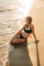Woman in bikini and a sea wave