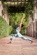 © Guille Faingold/Stocksy - High Lunge position outdoors.