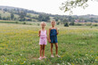 © STUDIO TAURUS/Stocksy - Girls standing in a meadow holding wildflowers