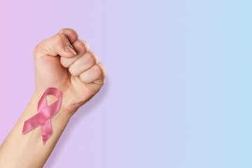 Wall Mural - First of person top view, raised female hand with a ribbon, cancer awareness