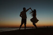 © Mauro Grigollo/Stocksy - Silhouette of a couple dancing on the beach