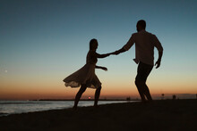 Couple Dancing On The Beach At Sunset