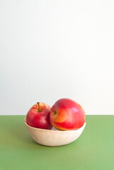 Wall Mural - Bright red sweet apples on white and green background with copyspace for your text.