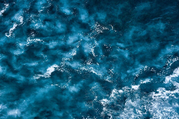 Wall Mural - Aerial view to seething waves with foam. Waves of the sea meet each other during high tide and low tide