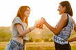 © Drobot Dean - White two women smiling and drinking soda while hiking outdoors