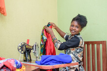 An African Female Tailor, Fashion Designer Or Dress Maker, Making Stylish And Fashionable Clothes With Sewing Machine In A Tailoring Workshop