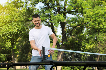 Sticker - Happy man playing ping pong outdoors on summer day