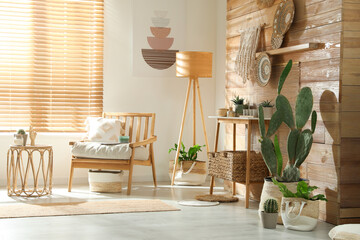 Poster - Stylish living room interior with comfortable wooden armchair and beautiful houseplants