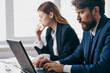 © SHOTPRIME STUDIO - colleagues sitting at a desk with a laptop communication finance professionals