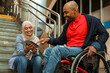 © Drobot Dean - Muslim woman and disabled man smiling while using tablet computer