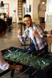© JustLife - Colleagues having fun at work. Businessman and businesswoman playing table soccer..