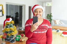 Happy African American Plus Size Woman In Santa Hat Making Christmas Video Call On Smartphone