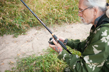 Wall Mural - Fisherman on river portrait. Senior concept, retiree, older man, hobby. Outdoor beautiful nature, fishing tools, fishing rod and tackle. Adds