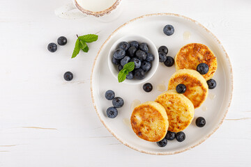 Sticker - Cottage cheese or curd fritters with honey and fresh blueberry. Healthy diet food, breakfast. Top view.