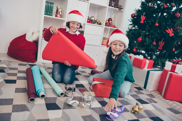 Poster - Photo of nice dreamy kids wrap paper package santa workshop concept wear x-mas hat jumper in decorated home indoors