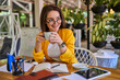 © Тарас Нагирняк - Smiling woman drinking coffee in her office