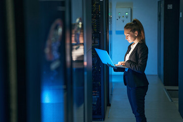female engineer working in server room at modern data center
