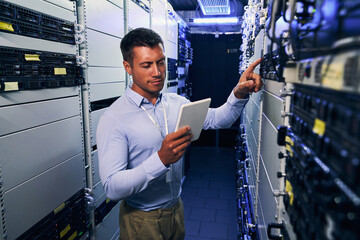 Wall Mural - IT technician consulting tablet computer during preventive maintenance