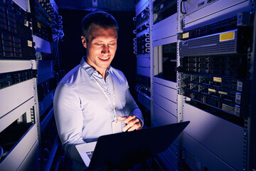 Wall Mural - Sysadmin working on notebook computer in server room